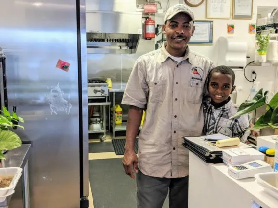 Weldy Gezehen and child in commercial kitchen